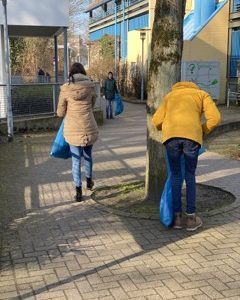 Schüler, die den Schulhof von Schmutz befreien, für Umweltbewusstsein an der IGS Celle